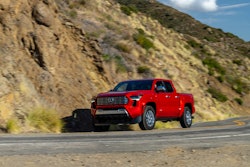 red 2024 Toyota Tacoma Limited driving on mountain road