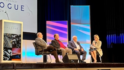 Three men and a woman discuss fleet concerns on a stage.