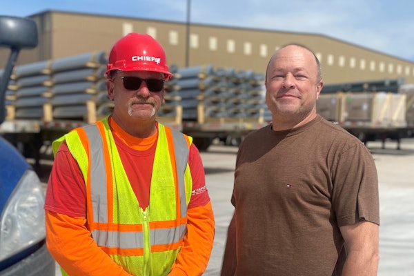 John Steffes, inbound materials coordinator at Chief Carriers, presenting driver Ron Jones with a red hat.