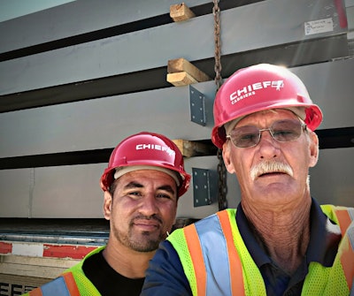 Rich Svitak, safety specialist at Chief Carriers, presenting driver Edwin Pena with a red hat.