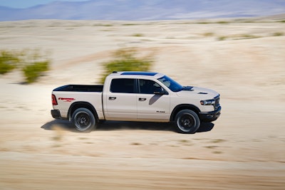 sand colored 2025 Ram 1500 Rebel X racing through the desert