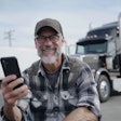 Older truck driver on a phone