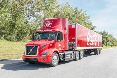 Coke-branded Volvo VNR Electric driving