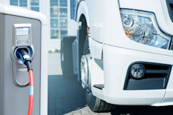 An electric truck next to a charging station.