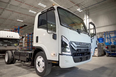 A white electric Isuzu truck on the assembly line