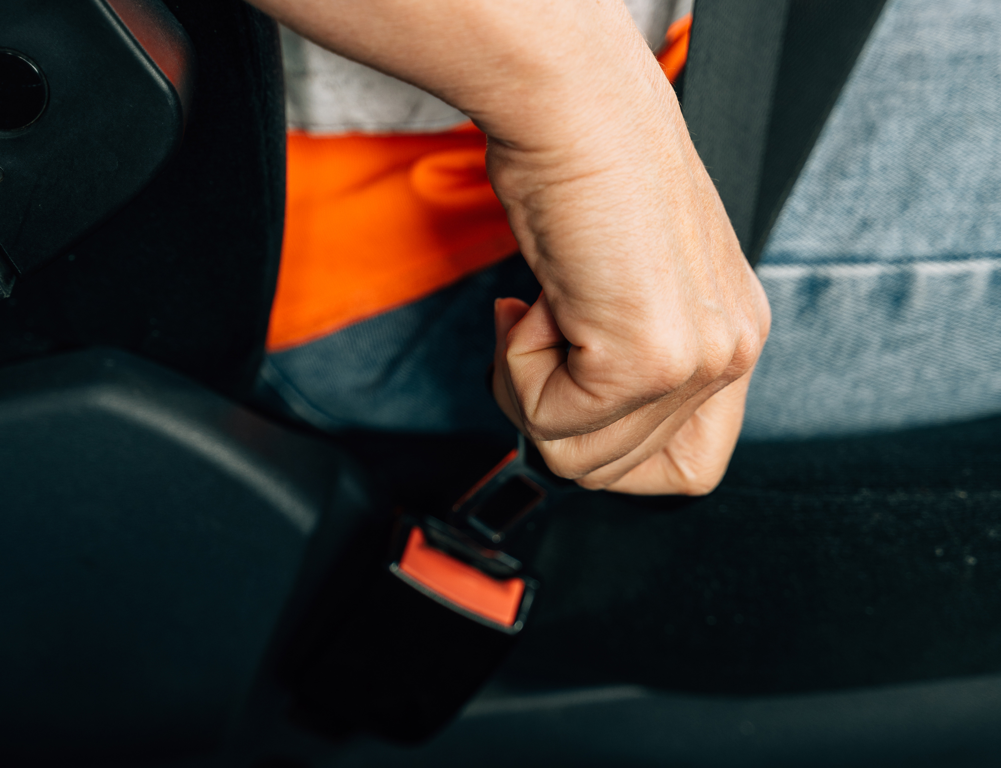 driver buckling a seat belt