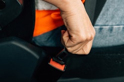 driver buckling a seat belt