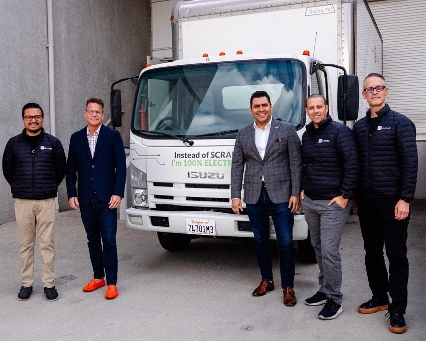 Five men stand in front of an electric Isuzu truck.