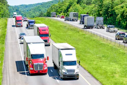 An interstate highway with traffic, including trucks.
