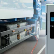 Electric semi-truck connected to charging station with blue sky background
