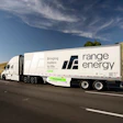 White Range Energy semi-truck driving on highway with grassy hills and blue sky