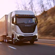 White Nikola Tre Class 8 semi truck driving at sunset