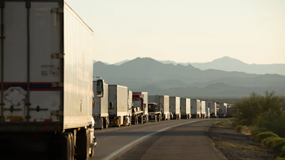 Semi trucks lined up on a crowded California highway.