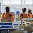 Orange industrial robots working on an automated assembly line with machinery