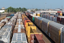 Crowded freight train yard with multiple colorful cargo containers and train cars