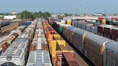 Crowded freight train yard with multiple colorful cargo containers and train cars