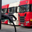 Electric truck charging station with red and white semi-trucks in parking lot