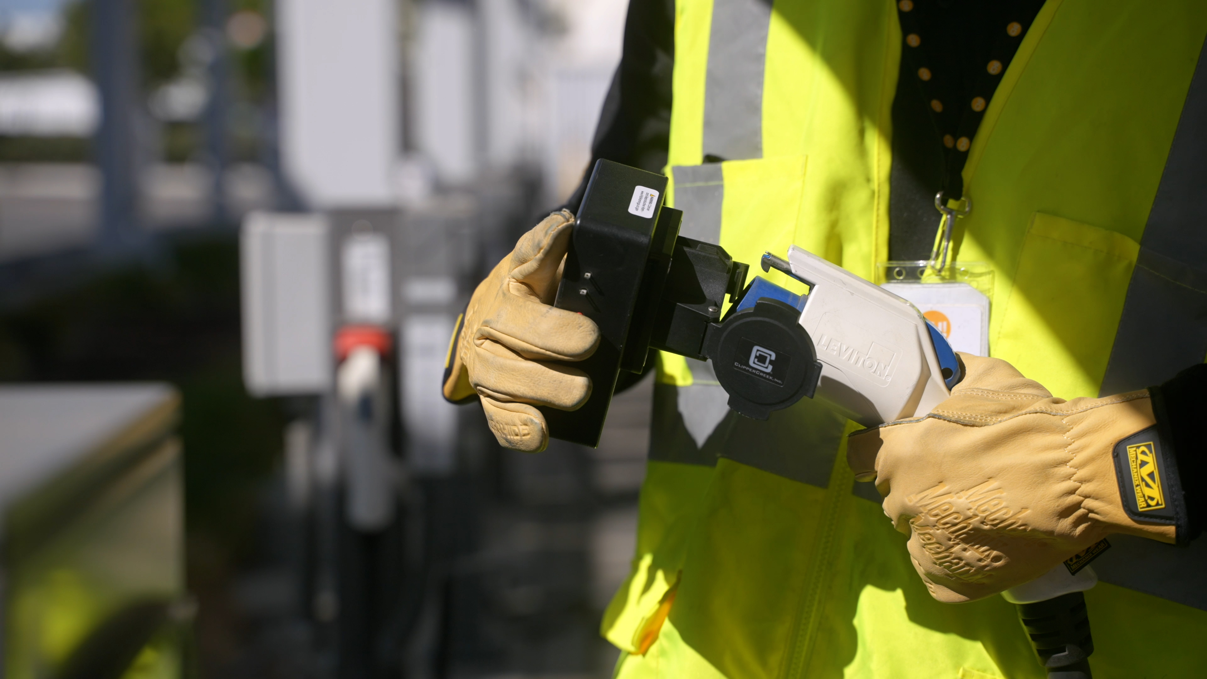 A ChargeHelp! technician is shown testing an EV charging connector.