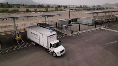 A truck from Velocity Truck Centers is show pulling out of an Greenlane EV charging terminal.