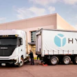 White Nikola Tre semi-truck connected to Hyla trailer in parking lot