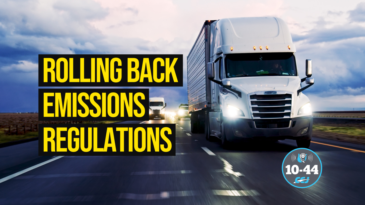 White semi-truck driving on highway with emissions regulations text overlay