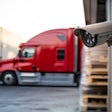 Security camera overlooking red semi-truck at warehouse loading dock