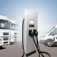 White trucks and vans parked near an electric vehicle charging station