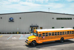 Yellow school bus parked in front of a gray Central States Bus Sales building