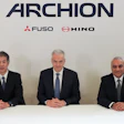 Daimler Truck and Toyota business executives seated in front of Archion corporate branding