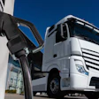 White semi-truck parked next to an electric vehicle charging station