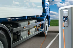 A battery-electric semi truck charging at a station, illustrating EV infrastructure in action.