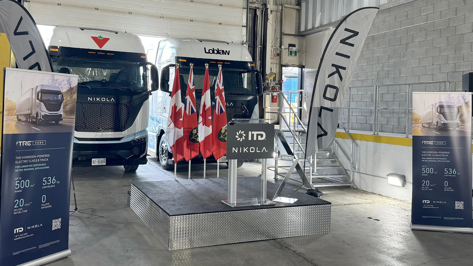 Hydrogen fuel cell and battery-electric semis, built by the now-bankrupt Nikola, parked inside a warehouse in July 2024 to mark the company's entry into the Canadian market.