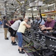 Manufacturing workers assembling industrial machinery in a factory production line