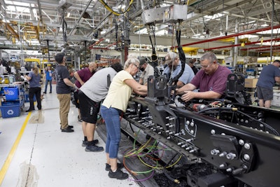 Manufacturing workers assembling industrial machinery in a factory production line
