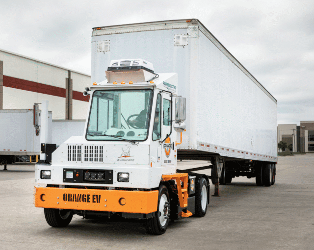 An example of an Orange EV electric yard tractor hauling a trailer.