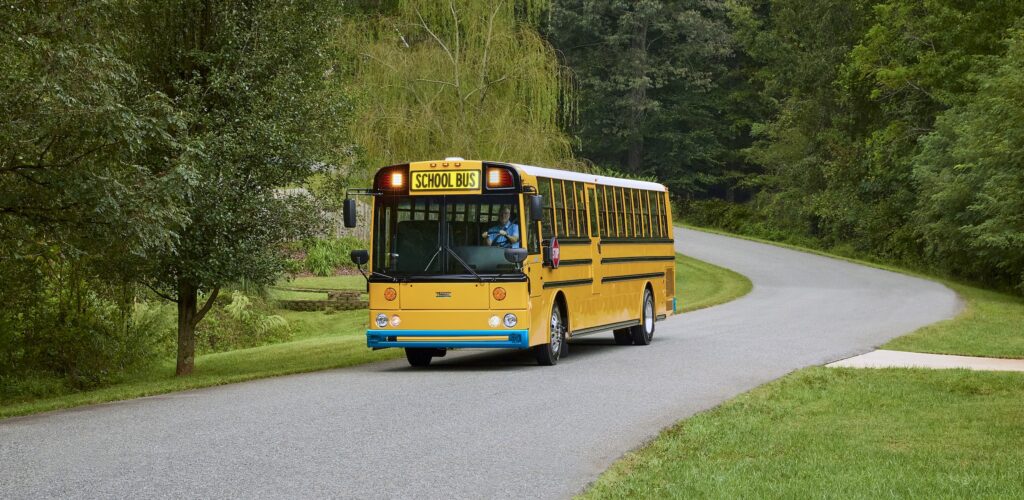 The new Thomas Built Type D battery-electric school bus, aka Wattson, driving down a neighborhood road.