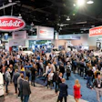 Crowded trucking industry trade show with Peterbilt and Kenworth displays