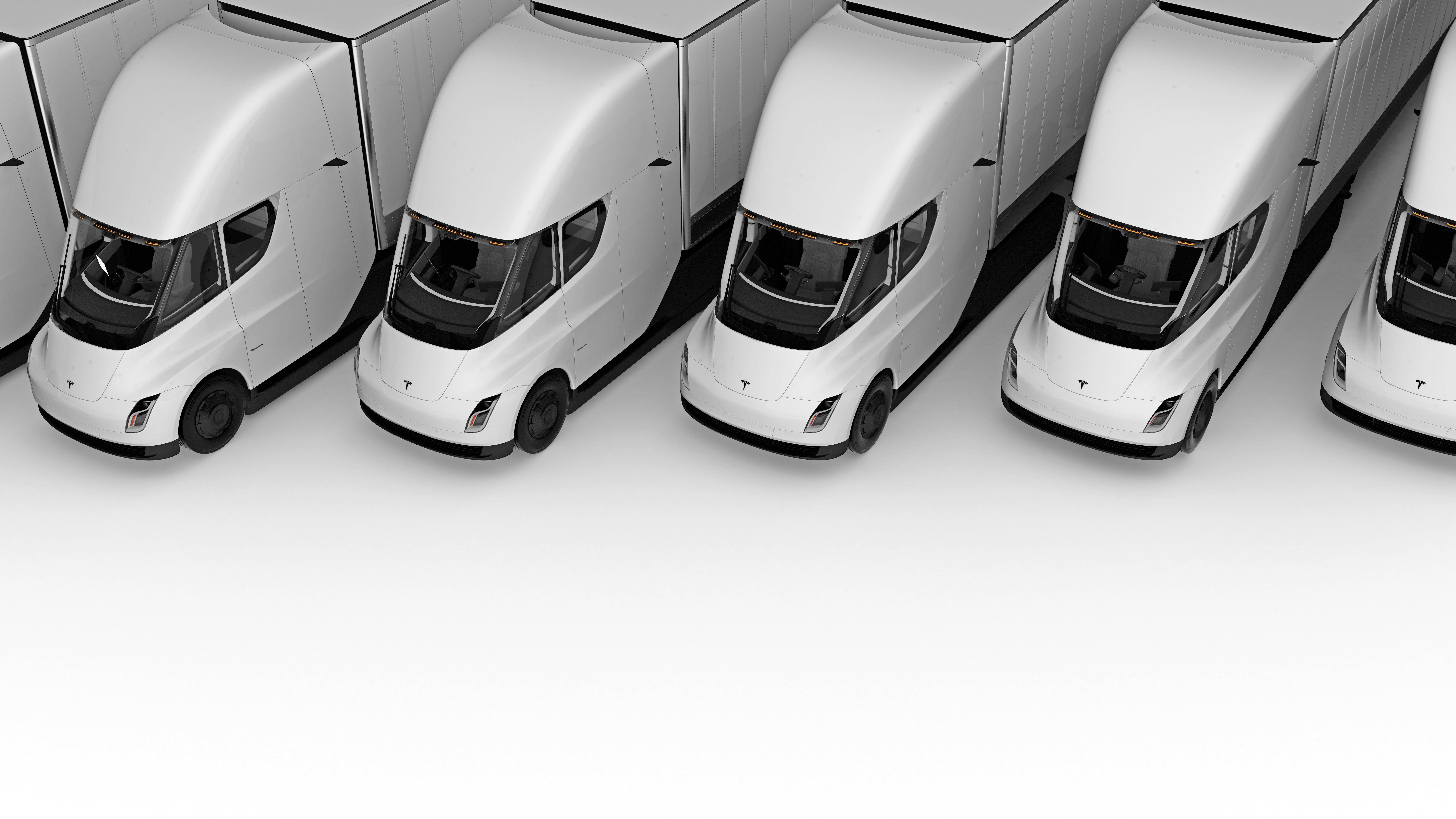 Row of white Tesla Semi electric trucks lined up in parallel formation