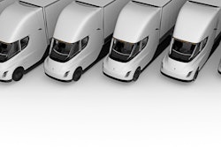 Row of white Tesla Semi electric trucks lined up in parallel formation