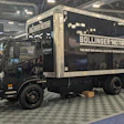 Black Bollinger Motors electric delivery truck on checkered floor at trade show