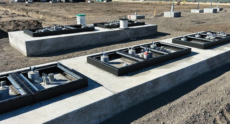 Concrete foundations with metal equipment bases on construction site