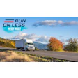 White semi-truck driving on mountain highway with autumn trees