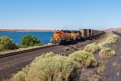 Moving BNSF locomotive in the desert area near the highway