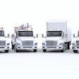 Four white commercial trucks lined up in a row on a neutral background