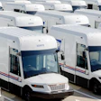 Multiple white recreational vehicles parked in organized rows