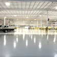 Large industrial warehouse with white delivery vans and yellow safety markers