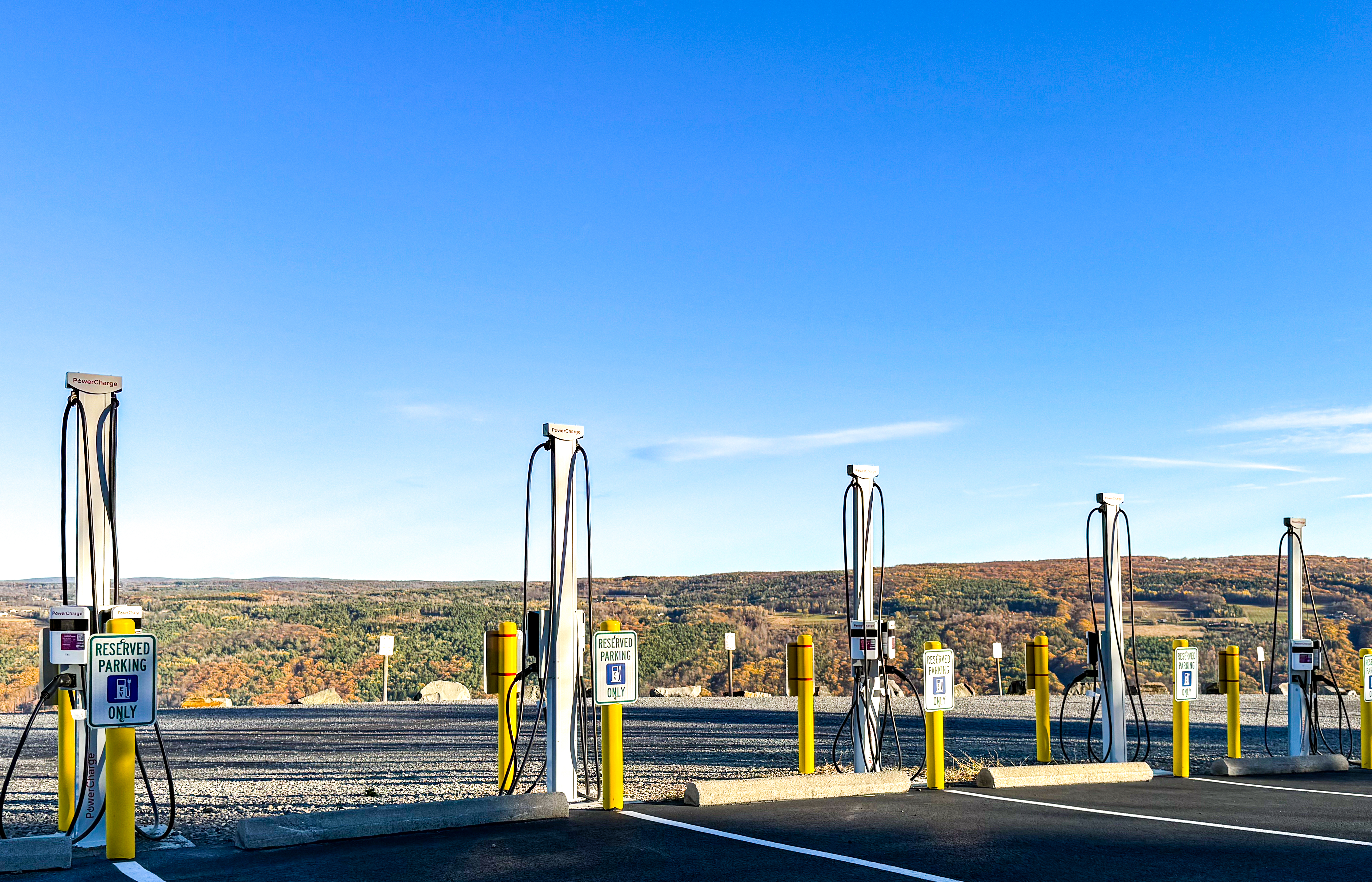 Electric vehicle charging station with multiple charging points overlooking fall foliage