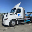 White Freightliner electric semi-truck with PG&E and Clean Fleet branding at charging station