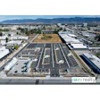 Aerial view of large parking lot with EV Realty logo, mountains and urban landscape in background