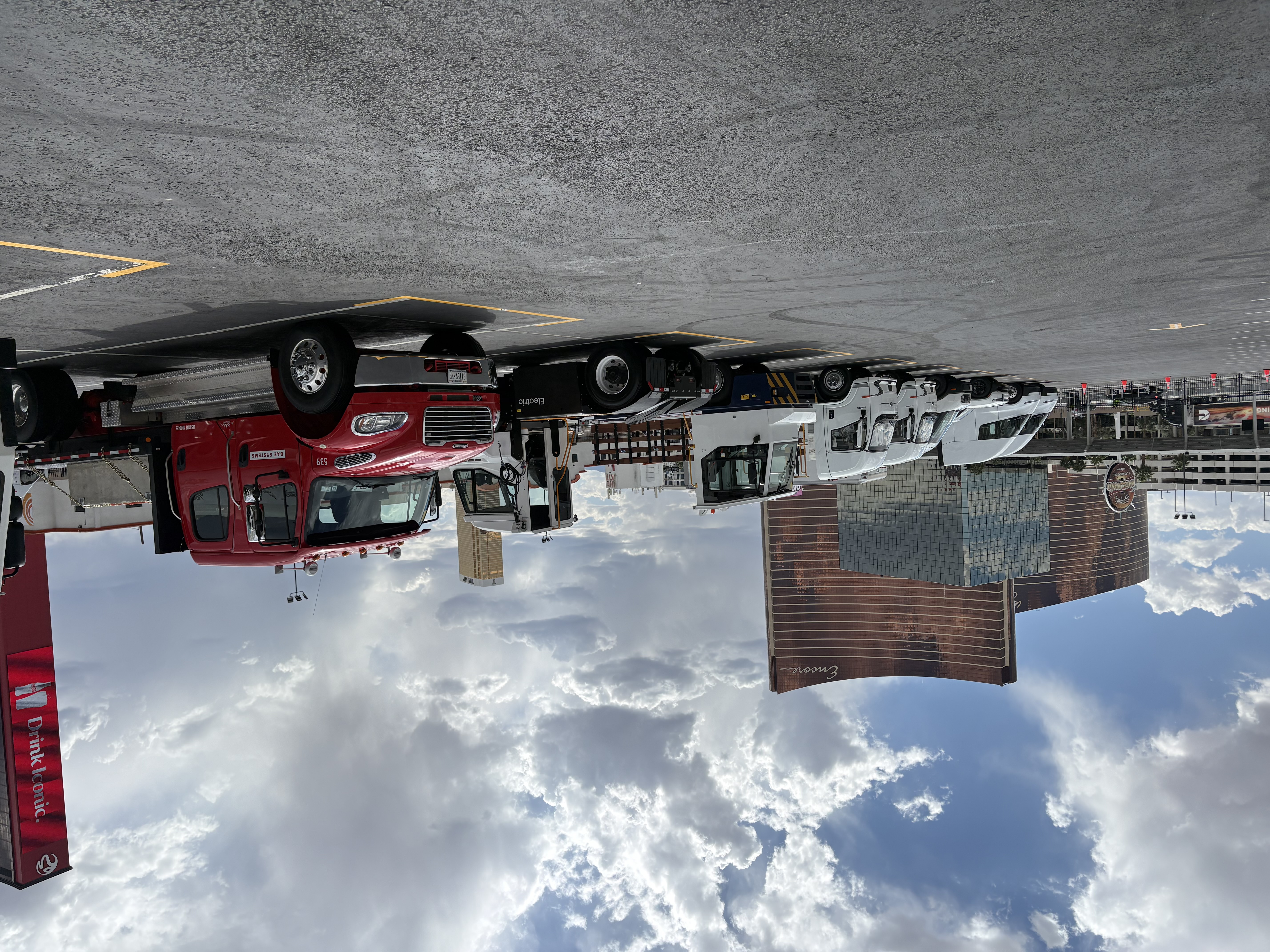 Commercial vehicles parked in lot with Encore casino and city skyline under cloudy sky